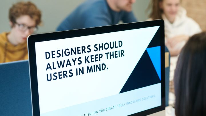 Auf einem Bildschirm ist zu lesen: »Designers should always keep theier users in mind«