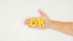 Kekse in den Formen der Buchstaben OK liegen auf einer Hand