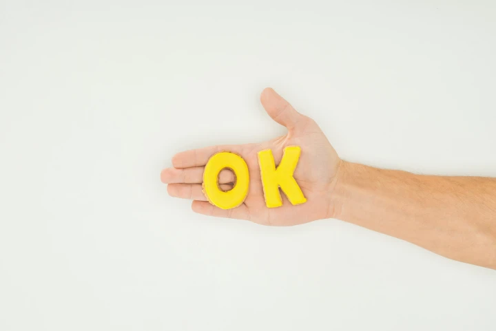 Kekse in den Formen der Buchstaben OK liegen auf einer Hand