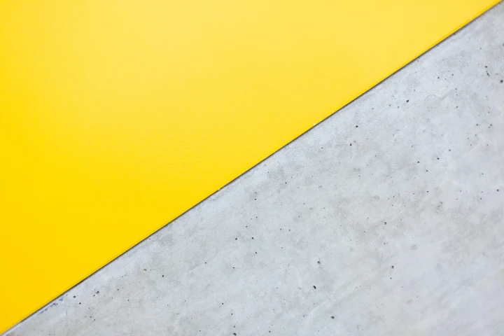 Eine Wand aus Beton, zur Hälfte gelb angemalt