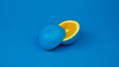 Eine blau angemalte Orange vor einem blauen Hintergrund