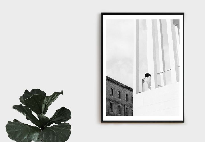 Ein eingerahmtes Bild von ein Mann, der von einem modernem Gebäude auf ein älteres Gebäude blickt